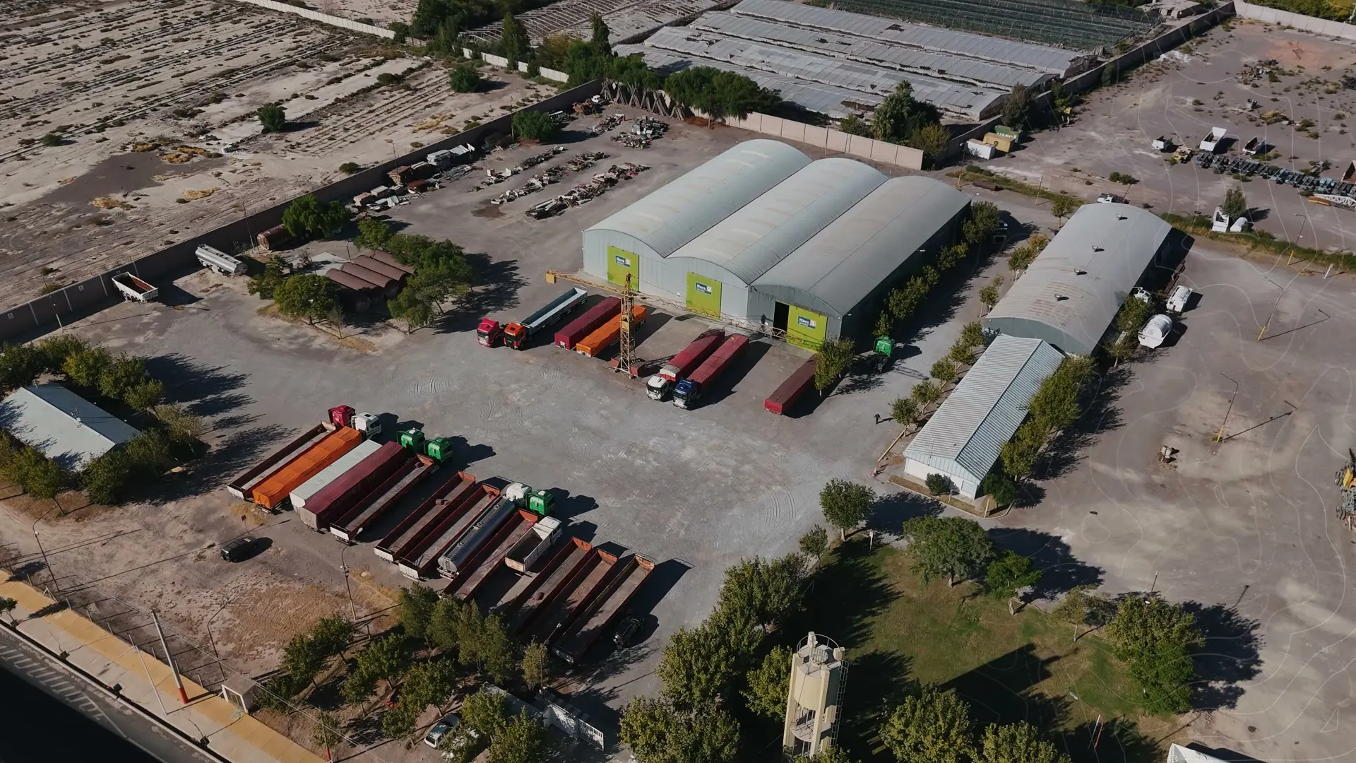 Vista aérea de la base operativa de Transporte Sanchez Huerta, con naves de depósito y semirremolques estacionados en el predio
